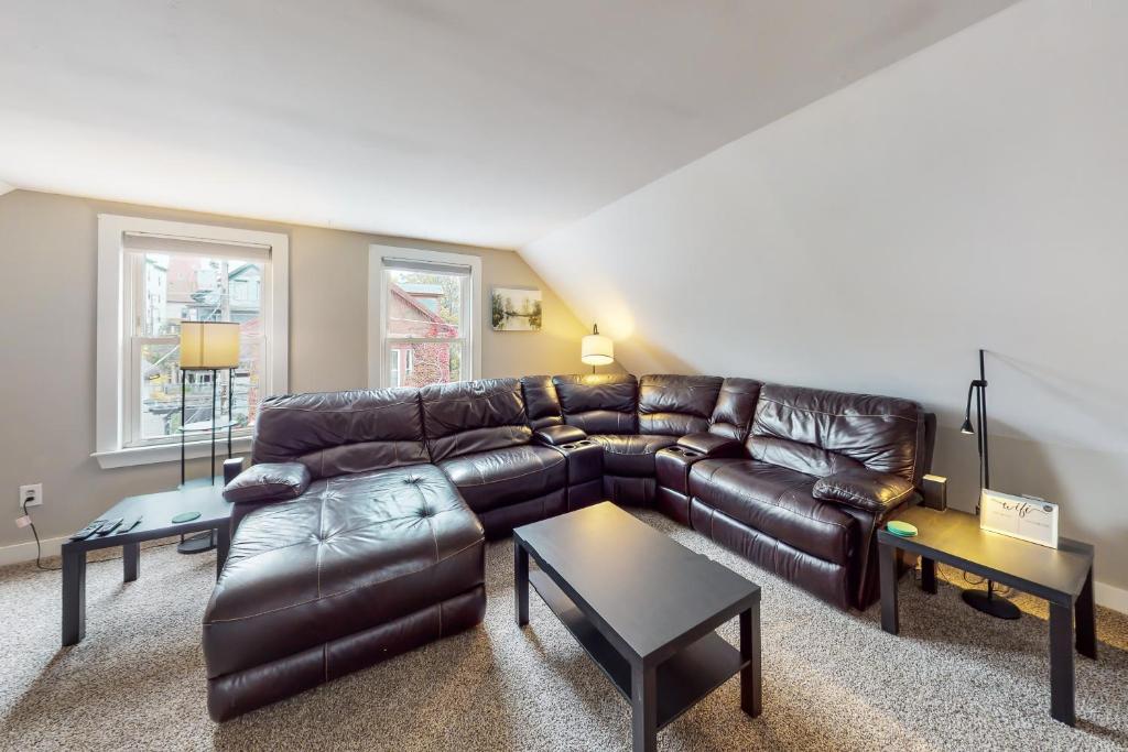 a living room with a leather couch and tables at East End Annex in Portland