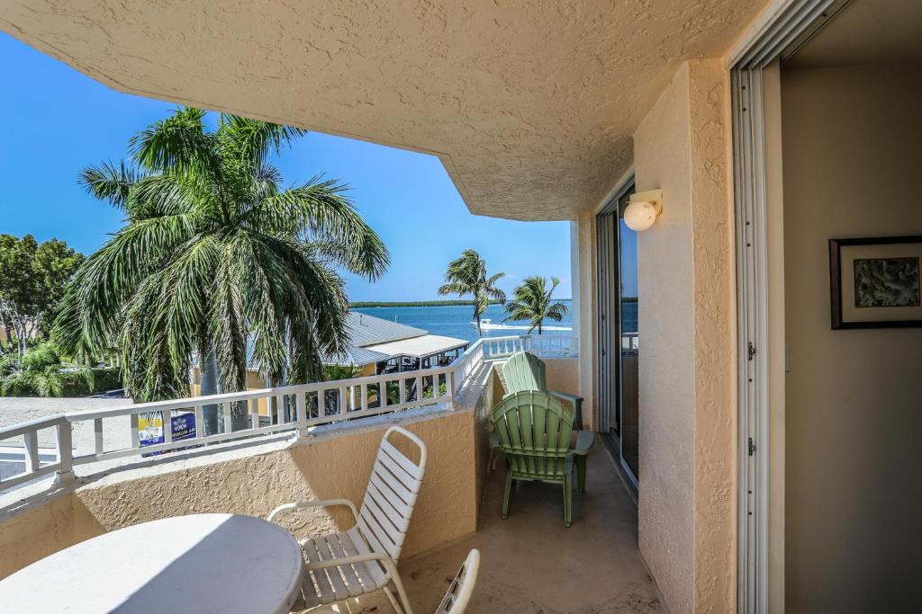 balcón con sillas, mesa y vistas al océano en Lovers Key Resort 206, en Fort Myers Beach