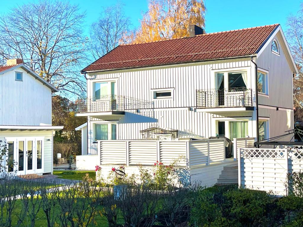 una casa blanca con una valla delante en 3 rooms with private kitchen & private bathroom 5B, en Gävle