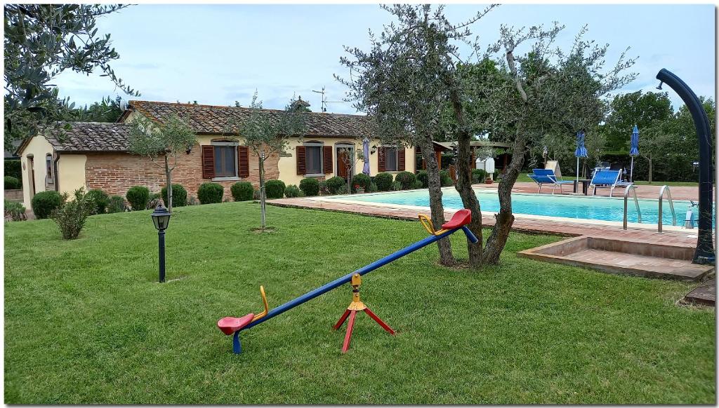 einen Spielplatz in einem Garten neben einem Pool in der Unterkunft Villino Cortona - Casa vacanze a Cortona con piscina privata WiFi, AC - Toscana - Nelle vicinanze Perugia, Assisi, Montepulciano, Pienza, Siena in Cortona