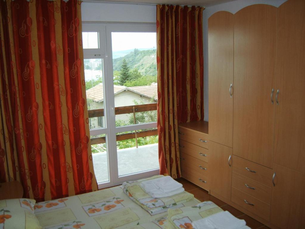 een slaapkamer met een bed en een raam met uitzicht bij Villa Snejanka in Balchik