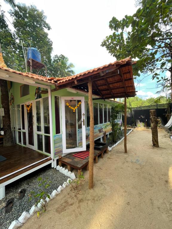 a small house with a porch and a deck at Art Resort Goa in Palolem