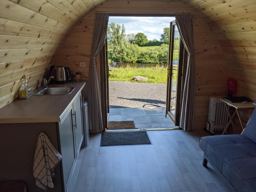 une cuisine avec un évier et une porte donnant sur une cour. dans l'établissement Killynick Glamping Oiney Fishing County Fermanagh, à Enniskillen