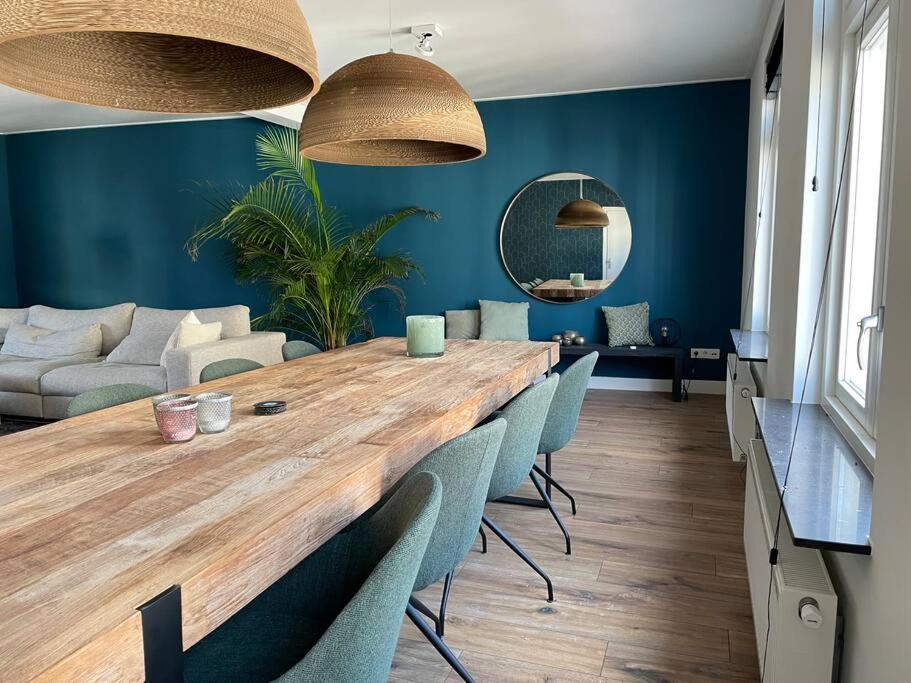 a dining room with a large wooden table and chairs at Spacious appartement in scenic quarter with huge roof terrace in Breda