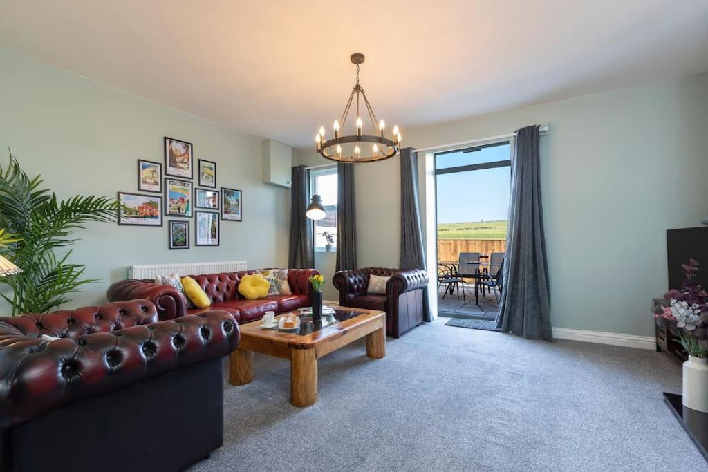 a living room with a couch and a table at Auckland View - a comfy & spacious 4bed with views in Coundon
