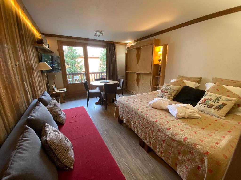 une chambre d'hôtel avec un lit et un canapé dans l'établissement Résidence CHALET DE SOLAISE - Studio 30 m2 - by MONTBLANC LODGE, à Val dʼIsère
