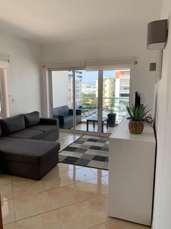 a living room with a couch and a table at ConVistaApartment with Pool in Portimão