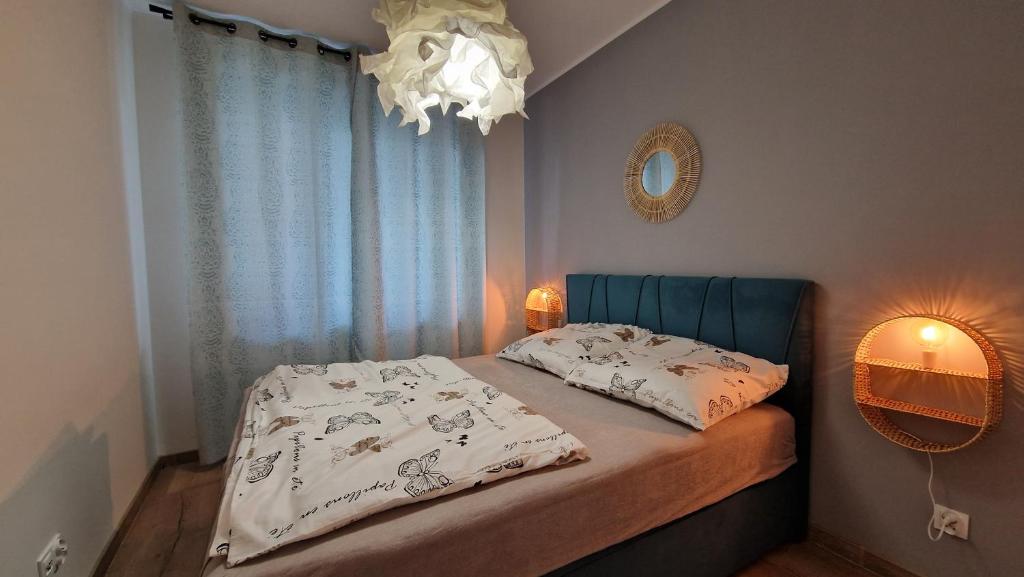 a bedroom with a bed and a chandelier at Apartamenty Września III in Września