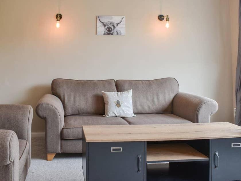 uma sala de estar com um sofá e uma mesa de centro em Ewe Cottage em Ashbourne