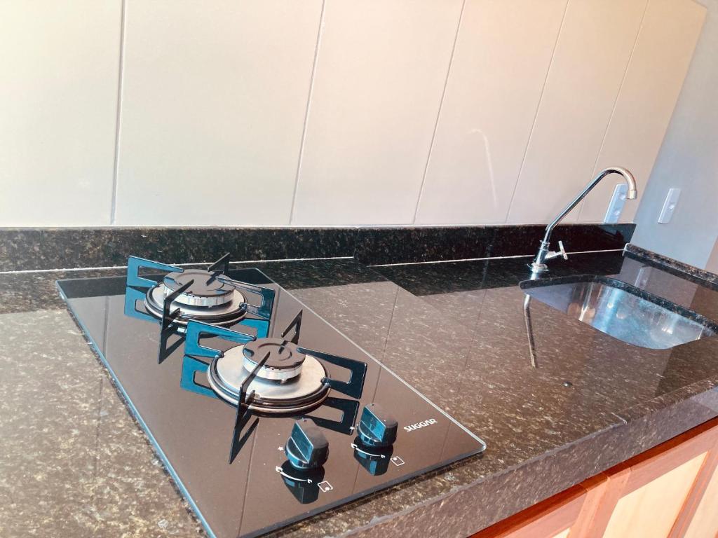 a kitchen counter with a stove and a sink at Portuá Chalés in São Miguel dos Milagres