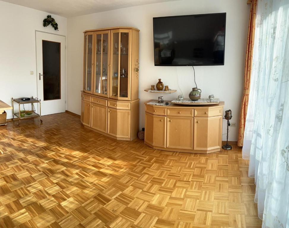 a living room with a wooden floor and a tv at Reichenbach Apartment in Bad Reichenhall