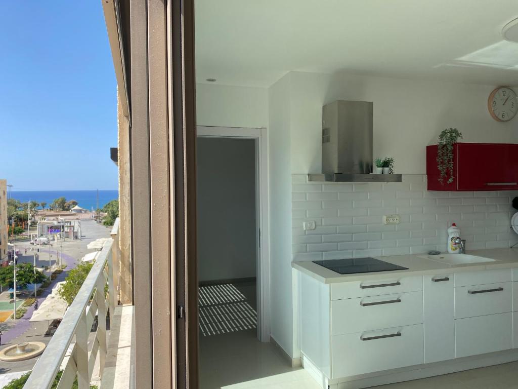 a kitchen with white cabinets and a view of the ocean at Vibe Place in Netanya
