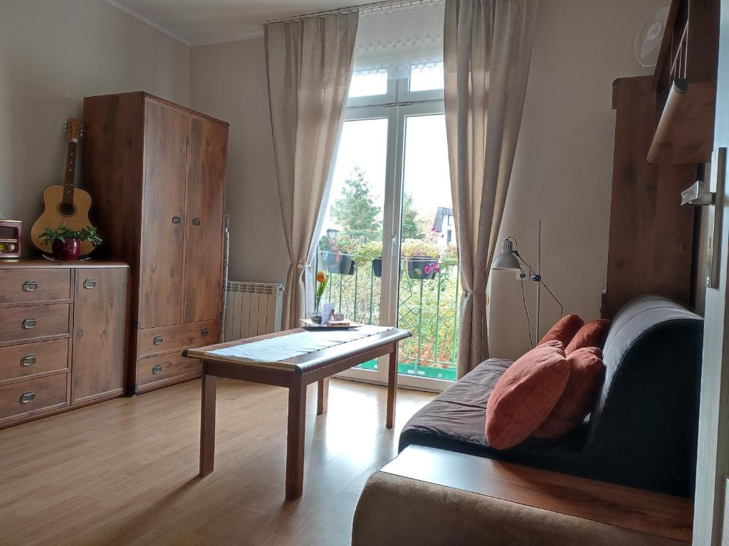 a living room with a table and a window at Apartament Olivia Centrum z zamknietym parkingiem in Gdańsk