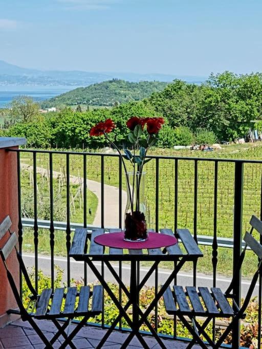 stół z wazonem z kwiatami na balkonie w obiekcie Il Lago Incantato w mieście Lonato