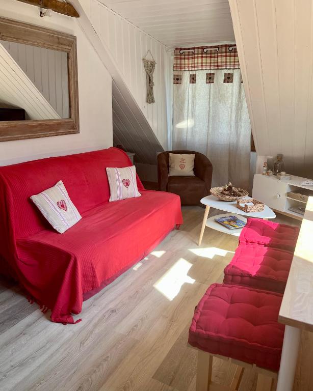 a living room with a red couch and a chair at Appartement Chalet Pra Loup in Uvernet