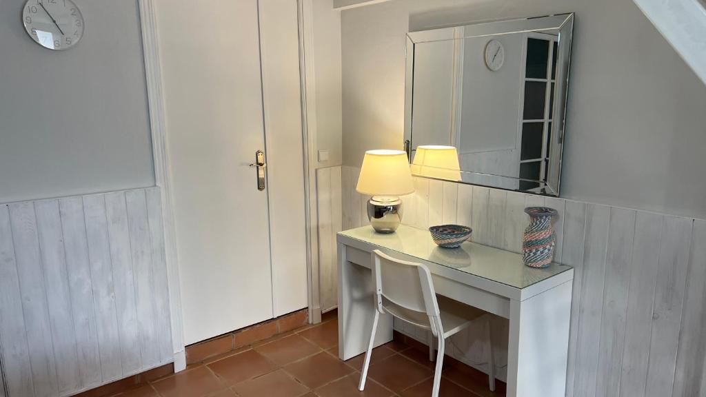 Habitación con escritorio, lámpara y espejo. en Acogedor estudio entrada independiente junto playa, en El Puerto de Santa María