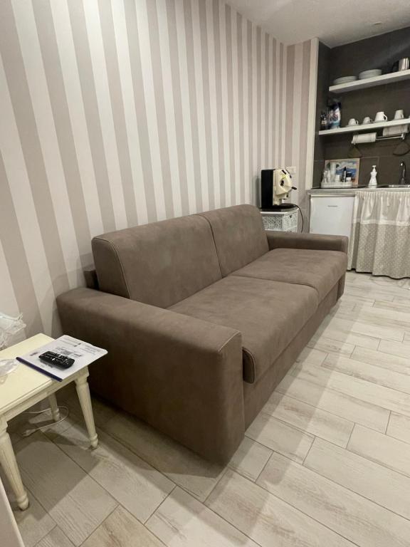ein braunes Sofa im Wohnzimmer mit einem Tisch in der Unterkunft B&B Piazza Plebiscito in Neapel
