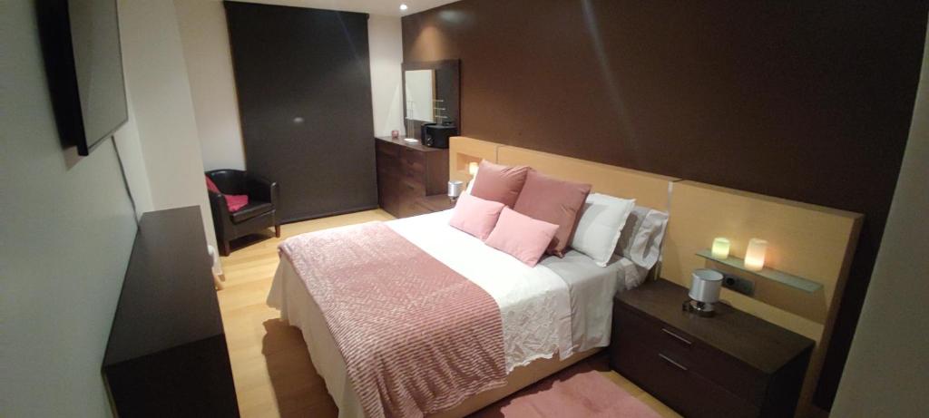 a bedroom with a bed with pink pillows at Piso Estación Termal II in Ourense