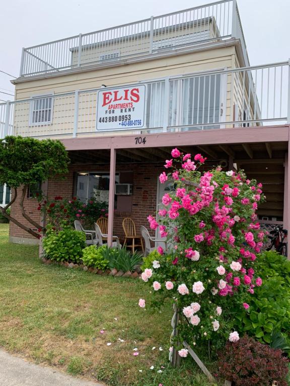 um edifício com um cartaz e flores cor-de-rosa em ELIS APARTMENT em Ocean City