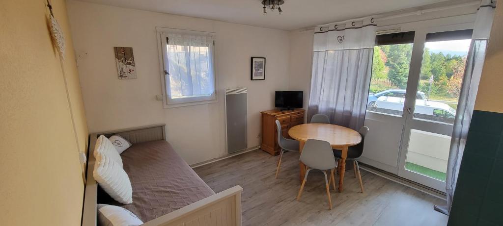 um pequeno quarto com uma mesa e uma cama e uma mesa e cadeiras em Studio Mouflon RDC balcon plein SUD garage FONT-ROMEU em Font Romeu Odeillo Via