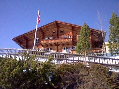 a large building with a flag in front of it at Chalet - Haus Ahorn Ost in Hasliberg