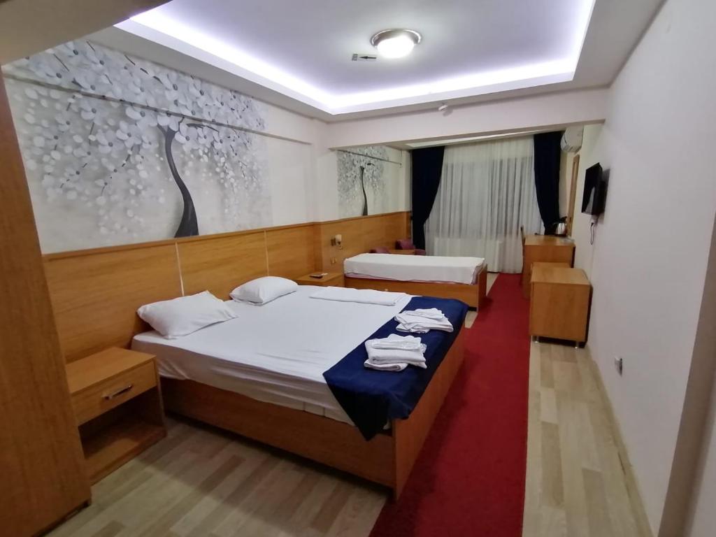 - une chambre avec 2 lits et un tableau mural dans l'établissement İHVA HOTEL PİERRELOTİ, à Istanbul