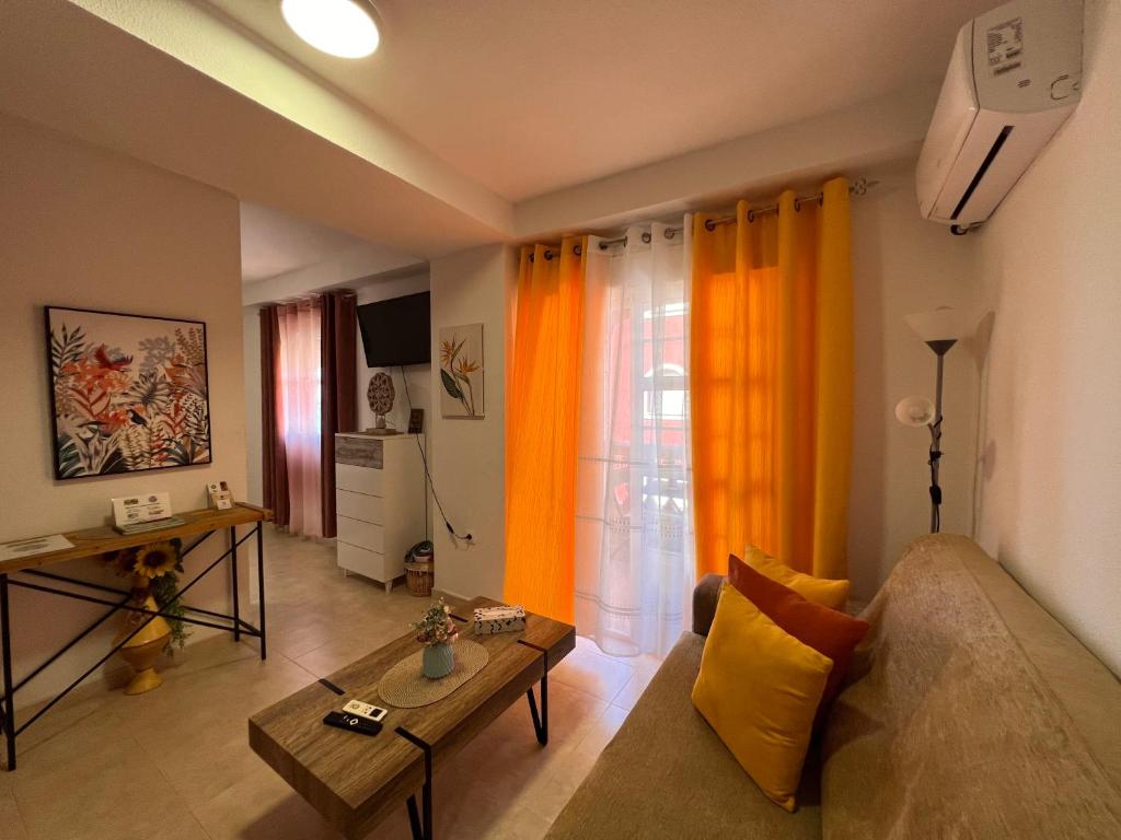 a living room with a couch and a table at Estudios Costavigía Mazagón by Ramona in Mazagón