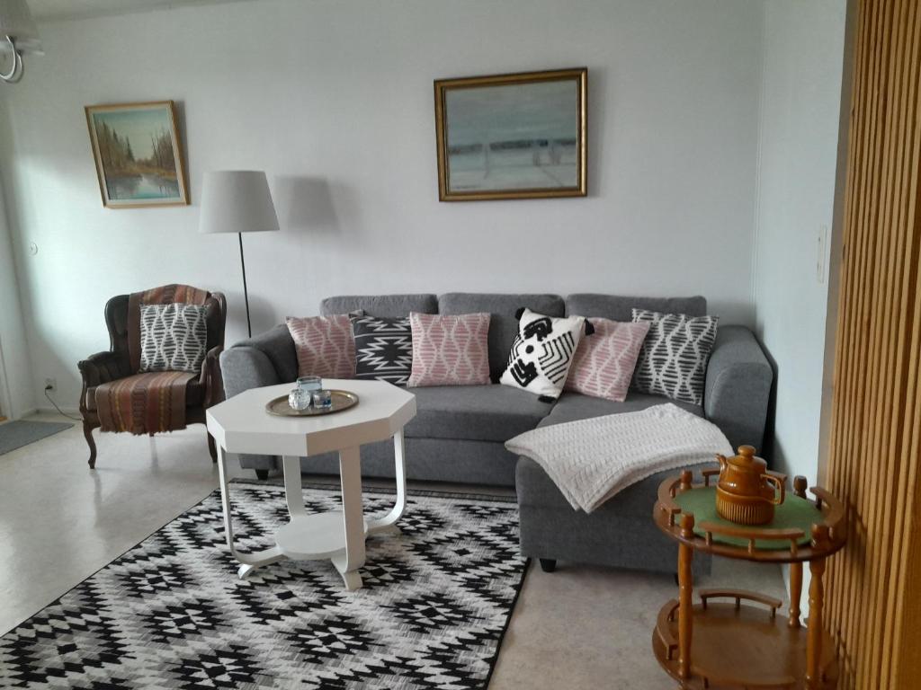 uma sala de estar com um sofá e uma mesa em Pieksämäellä saunallinen rivitalokaksio em Pieksamaki