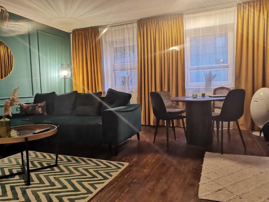 uma sala de estar com um sofá e uma mesa em Apartamenty Motyl em Bytom