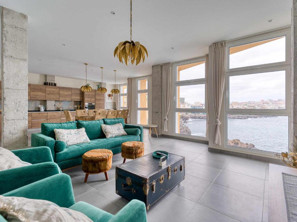 uma sala de estar com um sofá verde e algumas janelas em MCD Sea Sunset Deluxe em Las Palmas de Gran Canaria
