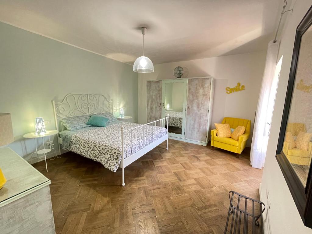 a bedroom with a bed and a yellow chair at Casa Garibaldi 41 in Perugia