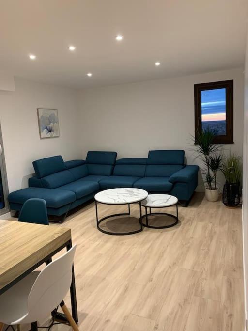 un salon avec un canapé bleu et une table dans l'établissement Appartement refait à neuf avec vue sur la ville, à Poitiers