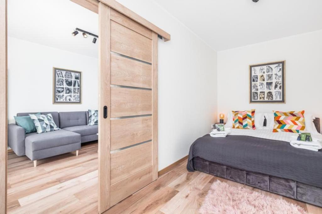 - une chambre avec un lit et une porte coulissante dans l'établissement Modern Riverside Apartment with Free parking space, à Szczecin
