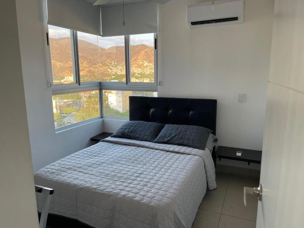 una camera da letto con un letto in una stanza con finestre di Super Confort Santa Marta a Gaira