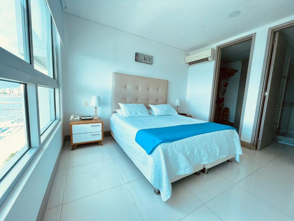 a bedroom with a large bed with a blue comforter at Apartamento Frenta a la Playa in Cartagena de Indias
