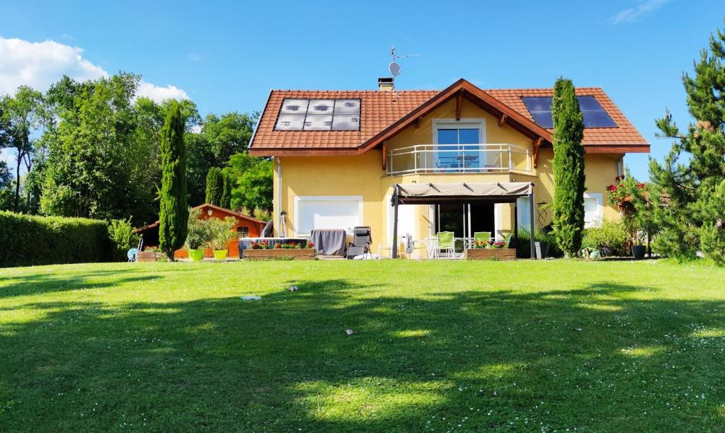 une maison avec une grande pelouse devant elle dans l'établissement Location Chambres Le Panorama - Aéroport Genève - Pays de Gex, à Chevry