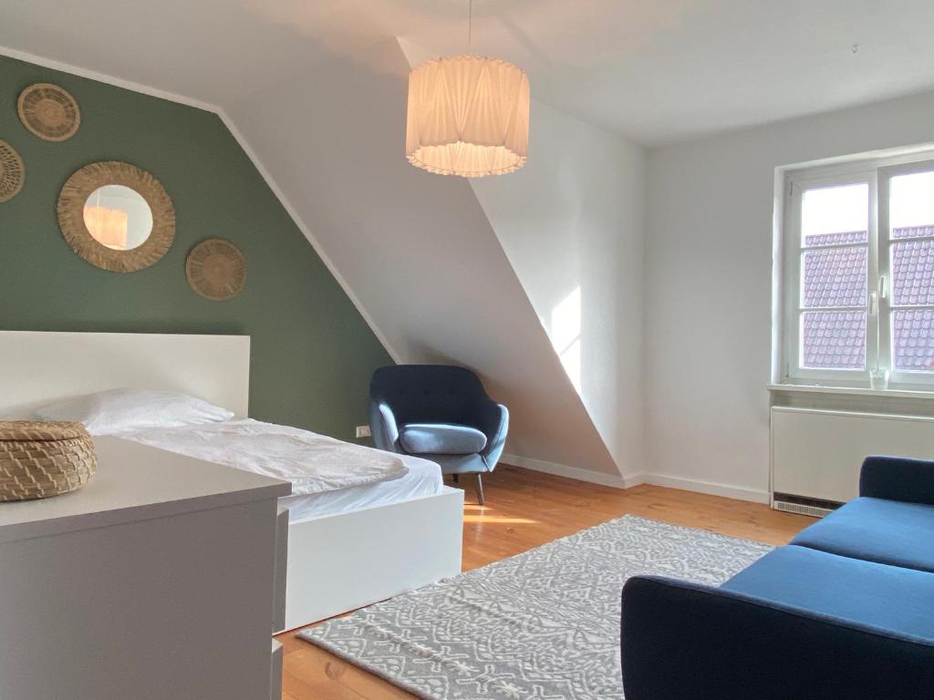 ein Schlafzimmer mit einem Bett und zwei blauen Stühlen in der Unterkunft Ferienwohnung Brötzingen im 4. OG in Pforzheim