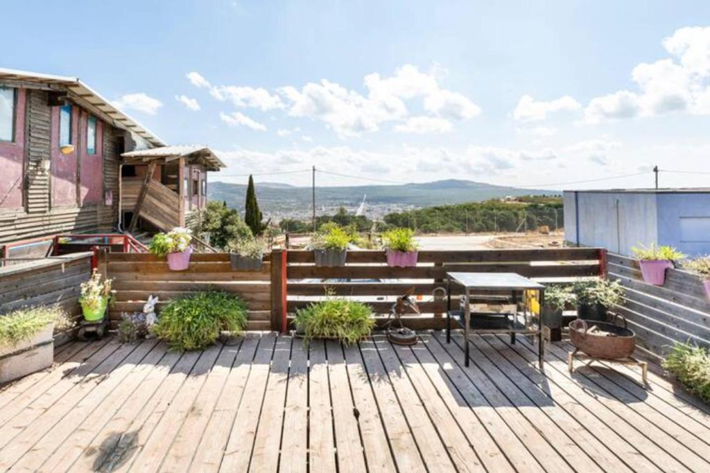 a wooden deck with a table on top of a house at Si-Har Chalets in Nimrod