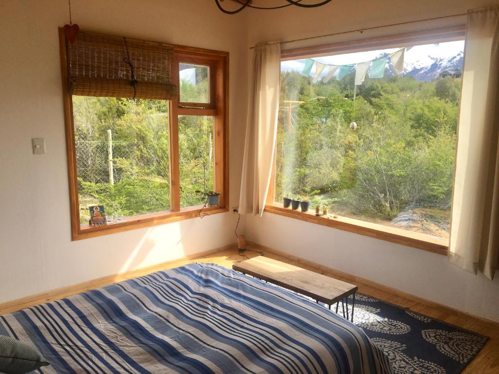 1 dormitorio con 1 cama y 2 ventanas en Casa luminosa y confortable rodeada de naturaleza en San Carlos de Bariloche