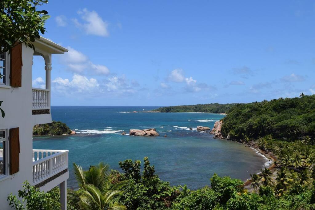 a view of the ocean from a balcony of a building at Oceanfront 3-bedroom villa with spectacular view! in Calibishie