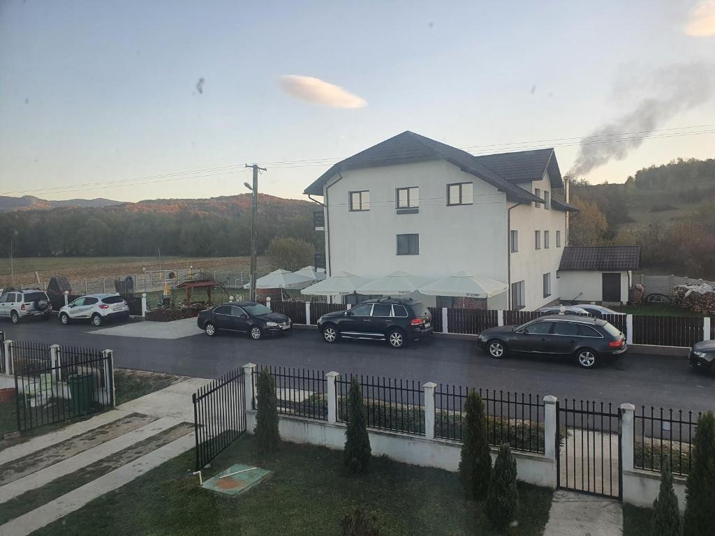 a group of cars parked in a parking lot next to a house at Pensiunea Ronicson in Miloştea