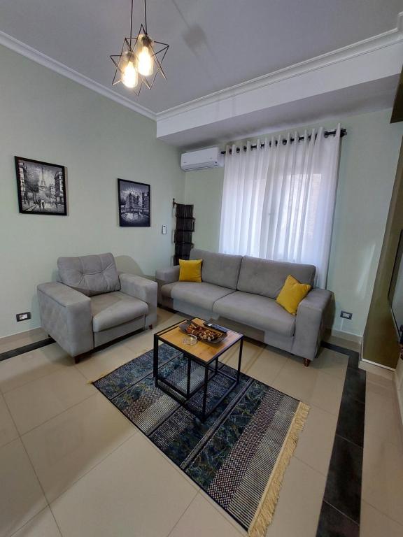 een woonkamer met een bank en een tafel bij Vila Tafa apartments ap3 in Tirana