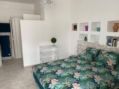 a living room with a bed with a floral blanket at Le 12 Boulevard Paoli in Bastia
