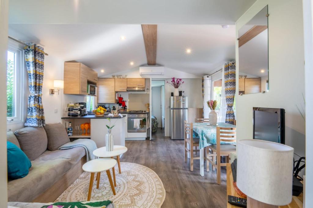 un salon et une cuisine avec un canapé et une table dans l'établissement Little John, à Fréjus