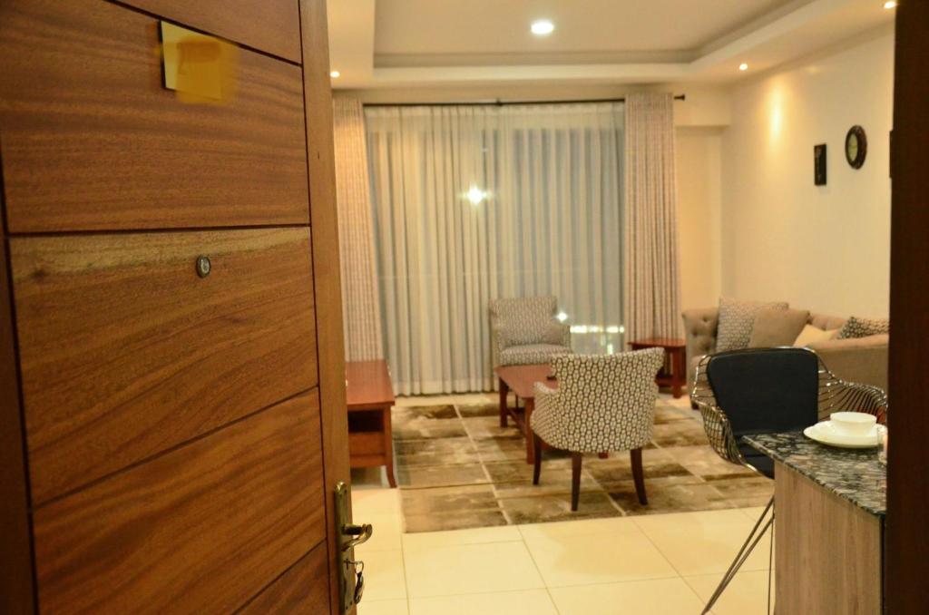 Zimmer mit einem Tisch und Stühlen sowie einem Wohnzimmer in der Unterkunft Yohana Residences in Nairobi