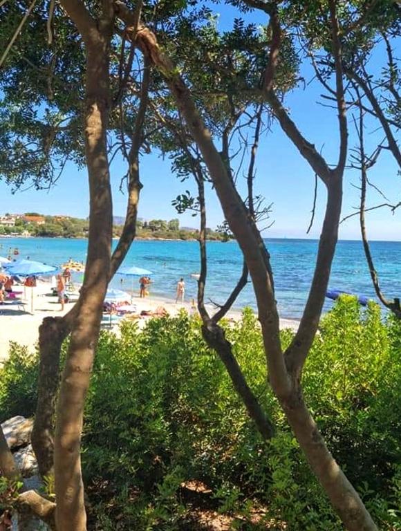 a beach with people on the sand and the water at Casa Patrizia in Olbia