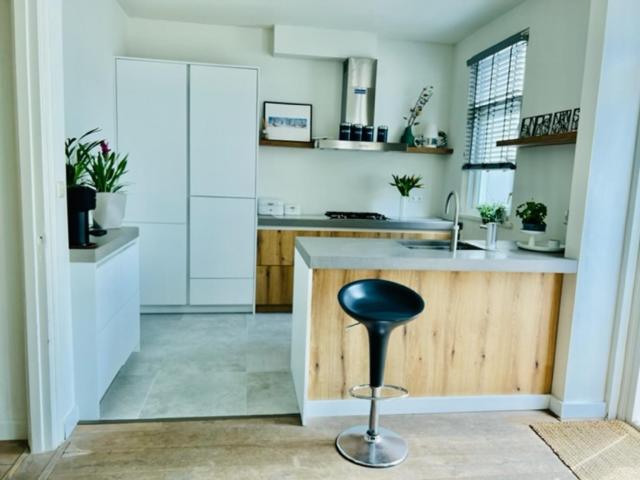 a kitchen with a counter and a stool in it at Family Beach House Zandvoort City Center in Zandvoort