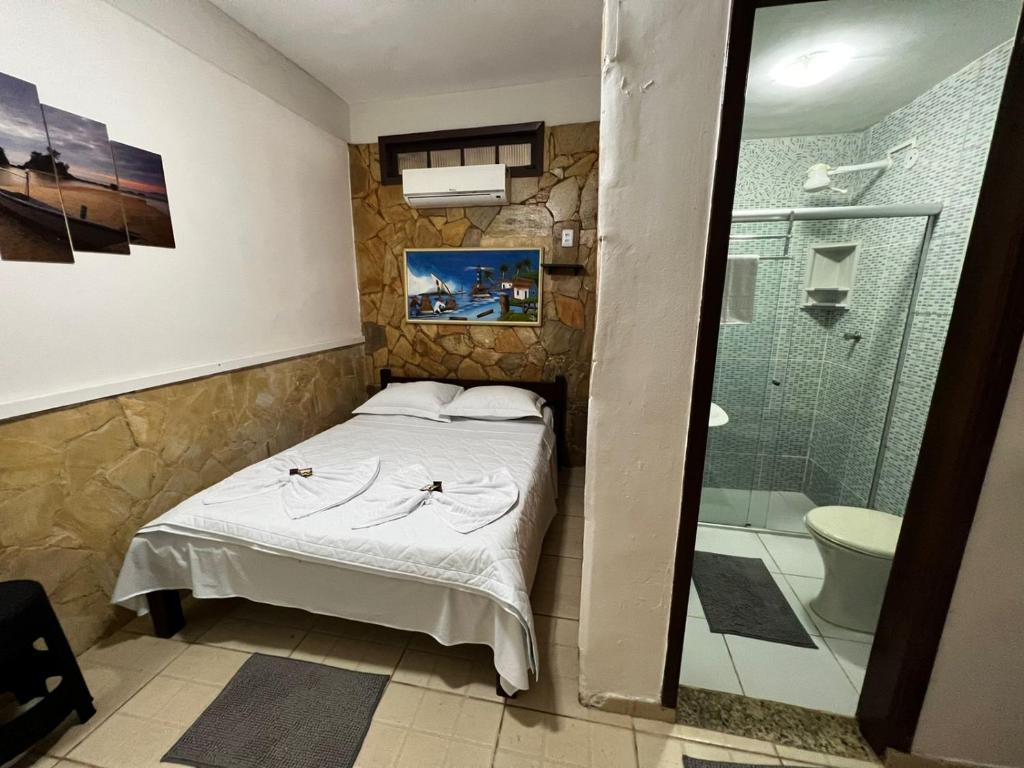 um pequeno quarto com uma cama e um chuveiro em Pousada Ilha Grande em Abraão