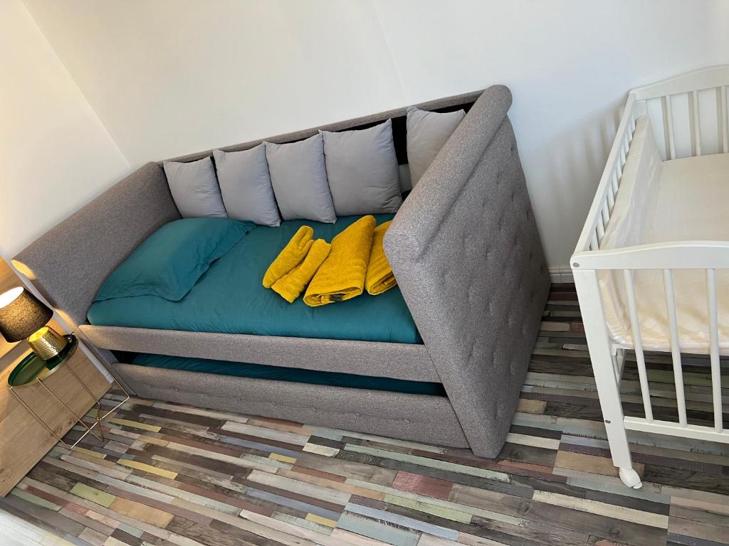 a bed in a crib with two yellow pillows at LE PARADIS APPARTEMENT in Martigues