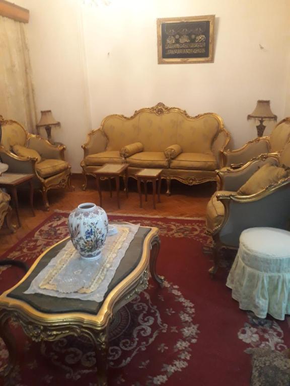 ein Wohnzimmer mit Sofas und einer Vase auf dem Tisch in der Unterkunft منطقة الاستاد بطنطا in Quḩāfah